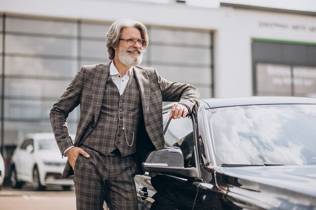 Senior business man in a car showroom choosing a car