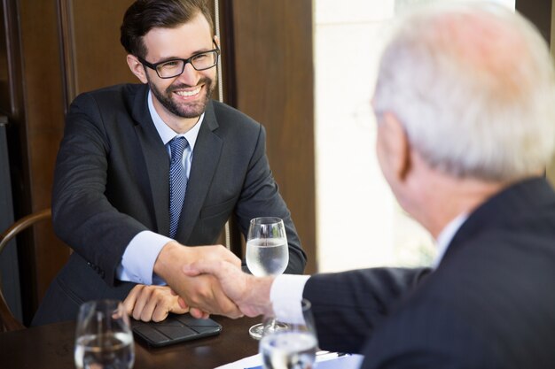 Senior business man receiving a handshake from another businessman