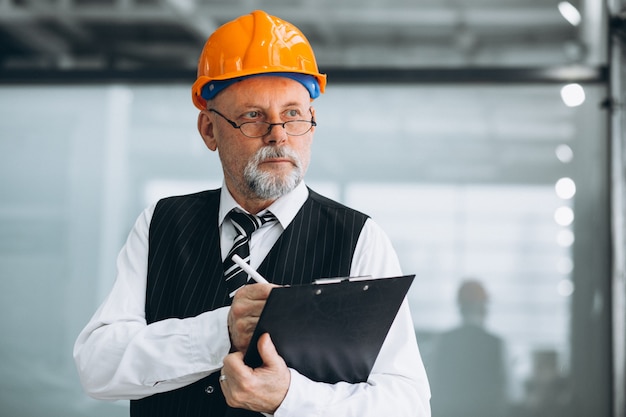 Foto gratuita architetto senior dell'uomo d'affari in un cappello duro