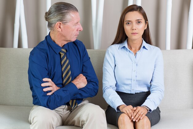 Senior Businessman and Female Colleague on Sofa