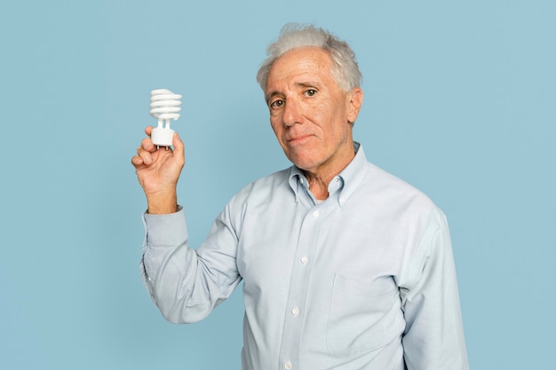 イノベーションキャンペーンのための電球を保持しているシニアビジネスマン