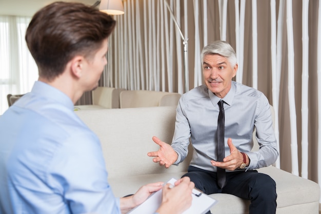 Senior Businessman Offering Proposal to Young Man