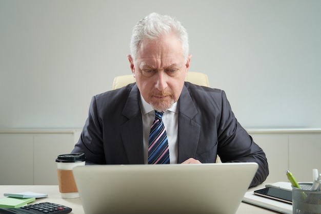 Free photo senior businessman at workplace