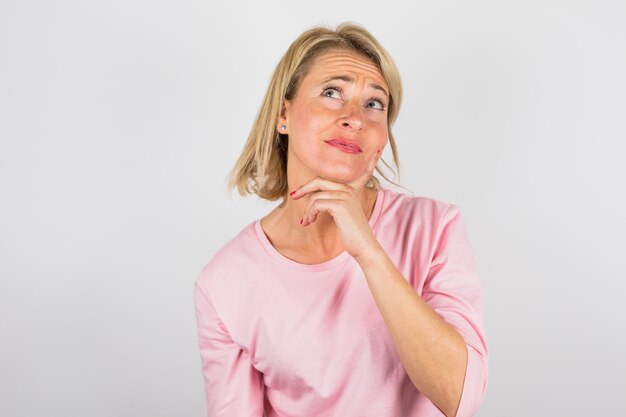 Senior charming pensive woman in rose blouse