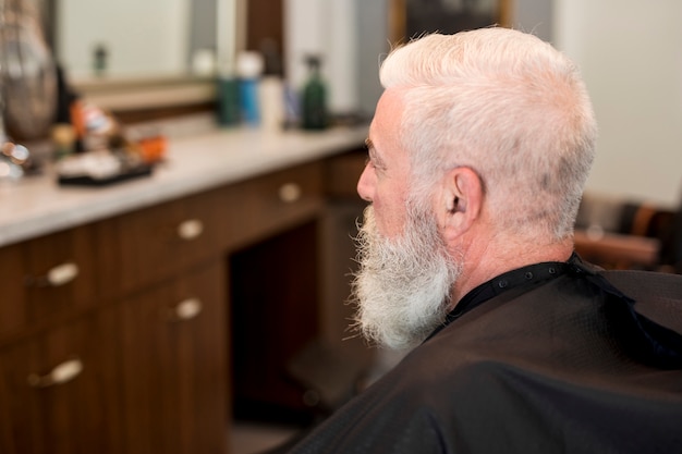 Senior client with cape in barbershop