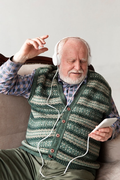 Senior on couch playing music