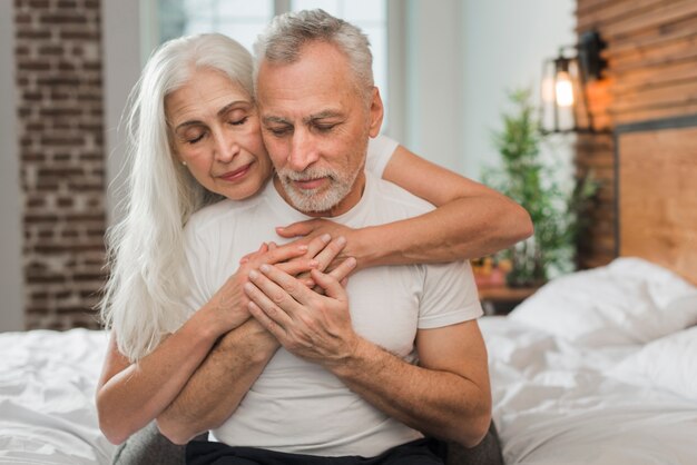 Senior couple in bed hugging