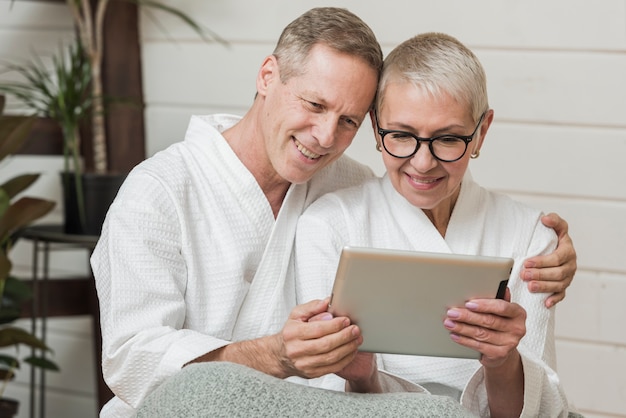 Senior couple being close while looking on a tablet