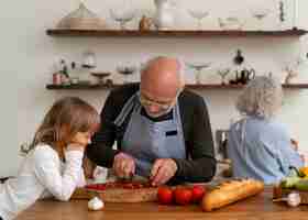 Foto gratuita coppia anziana che cucina insieme in cucina con il nipote