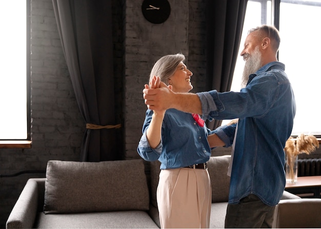 Free photo senior couple dancing at home