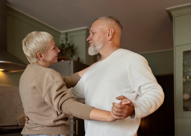 Free photo senior couple dancing at home