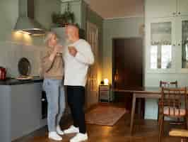 Free photo senior couple dancing at home