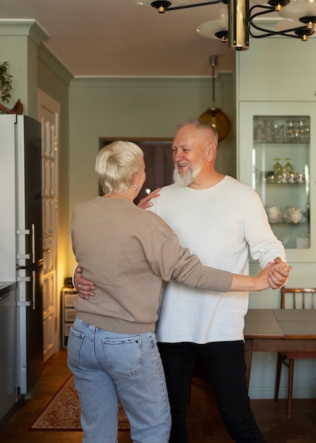 Пожилая пара танцует дома