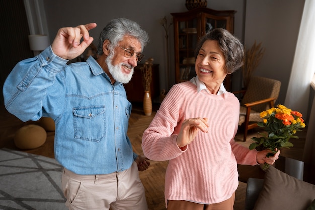 Пожилая пара танцует в помещении, средний план
