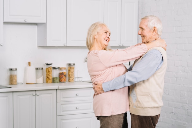 Foto gratuita coppie senior che ballano nella cucina