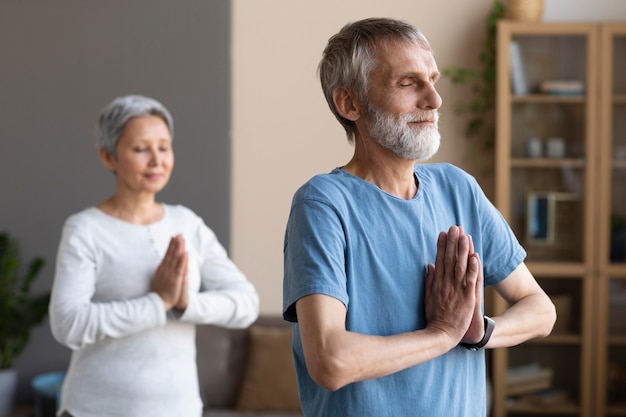 Foto gratuita coppia senior che esercitano a casa