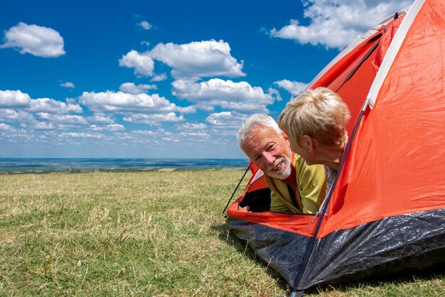 テントの中で休んでいる年配のカップル
