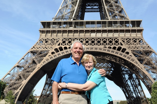 パリ、エッフェル塔の前で抱くシニアカップル