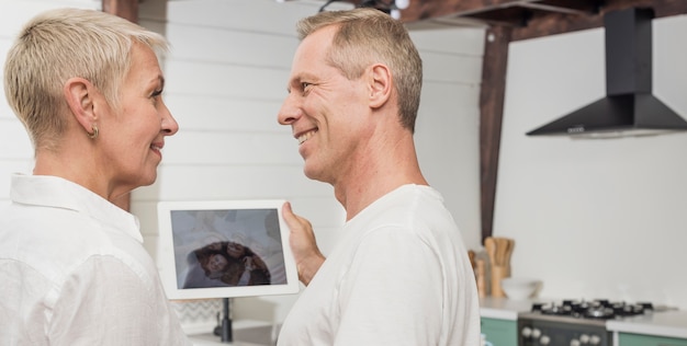 Senior couple holding a tablet while looking at each other