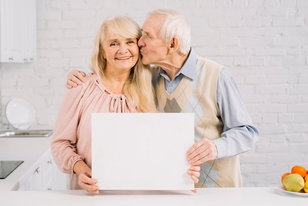 Senior couple holding template in kitchen