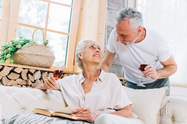 Senior couple holding wine glasses in hand looking at each other