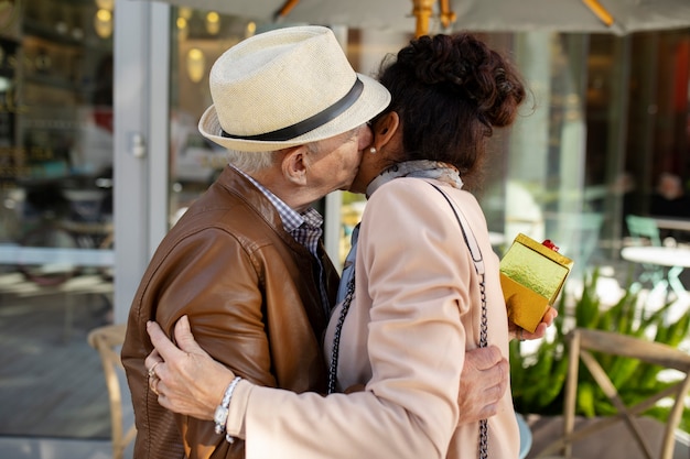 Пожилая пара обнимается и целуется во время свидания