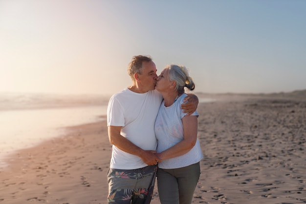 Пожилая пара целуется с видом на пляж