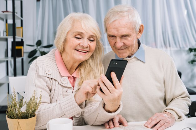 Пожилая пара смотрит на смартфон