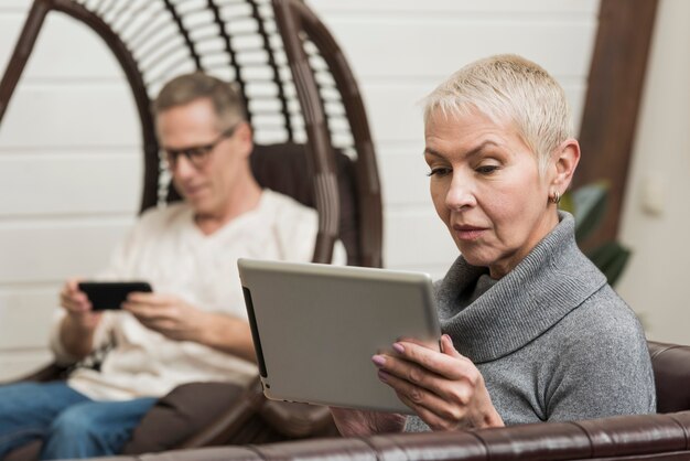 Пожилые супружеские пары, глядя через свои устройства