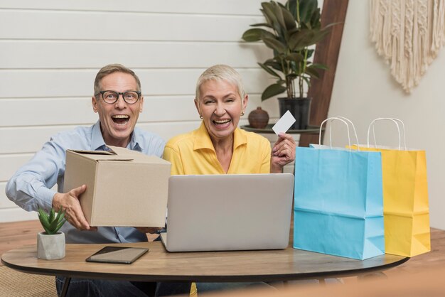 Coppie senior che aprono i loro sacchetti della spesa e scatole