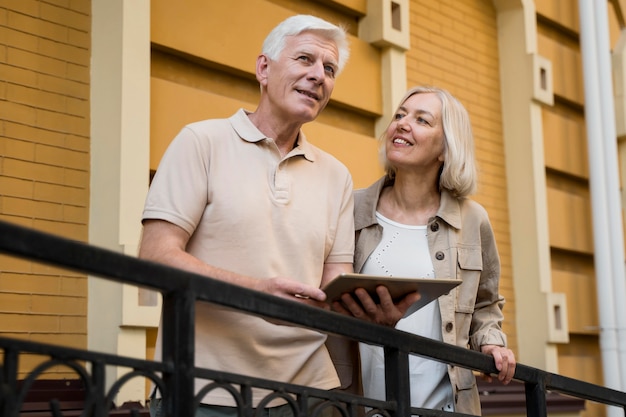 Free photo senior couple out in the city with tablet