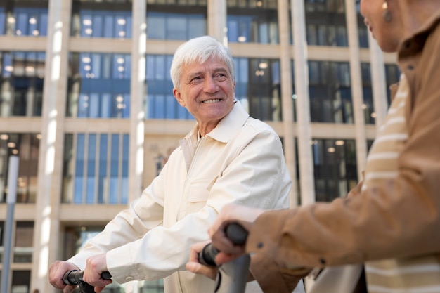 Coppia senior in sella a uno scooter elettrico in città