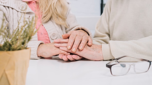 Free photo senior couple at table holding hands