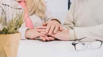 Free photo senior couple at table holding hands