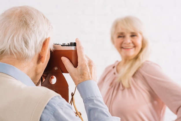 Free photo senior couple taking photo in kitchen