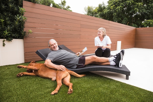 庭で犬と年配のカップル