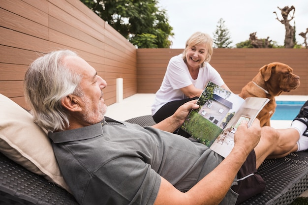 Free photo senior couple with dog in garden