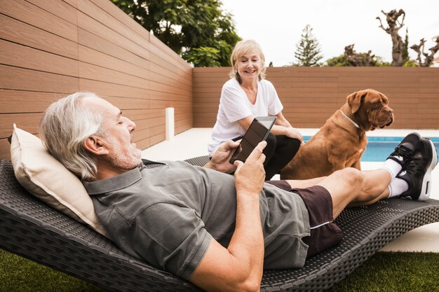 Senior couple with dog in garden