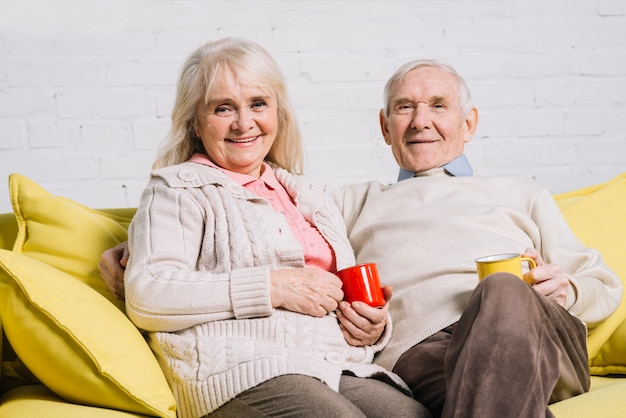 Senior couple with mugs of coffee
