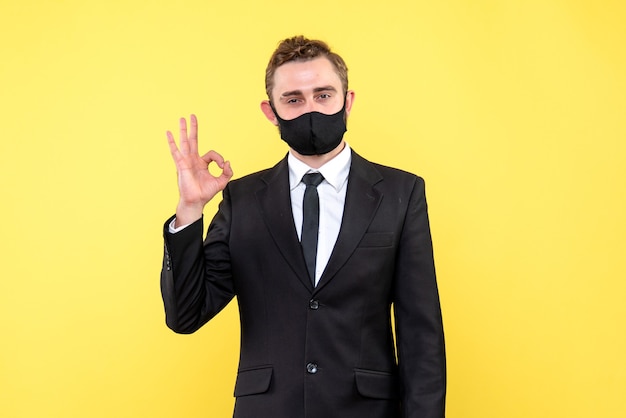 Senior employer making ok gesture while standing on yellow