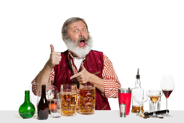 Старший эксперт-мужчина-бармен с пивом, изолированным на белой стене. Международный день бармена, бар, алкоголь, ресторан, пиво, вечеринка, паб, концепция празднования Дня Святого Патрика