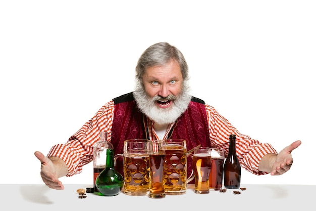 The senior expert male barman with beer at studio isolated on white wall