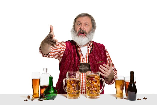 The senior expert male barman with beer at studio isolated on white wall