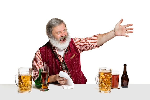 The senior expert male barman with beer at studio isolated on white wall