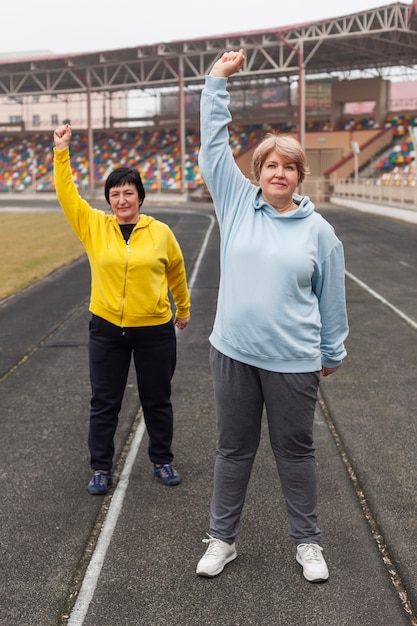 スタジアムで運動シニア女性のカップル