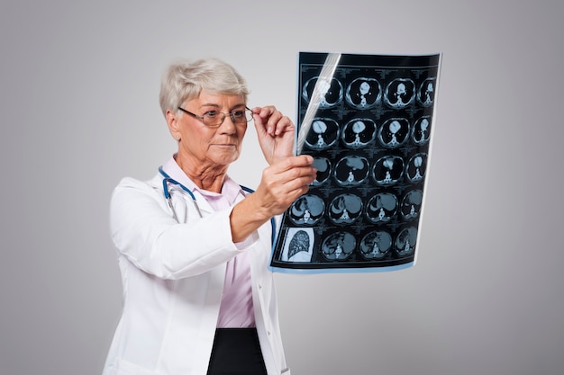 Старшая женщина-врач анализирует рентгеновское изображение Бесплатные Фотографии