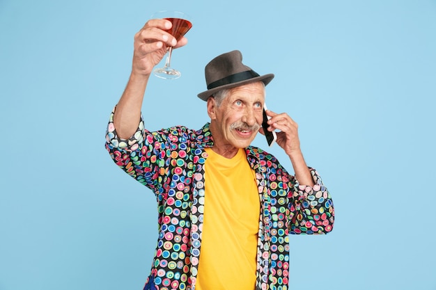 Free photo senior hipster man in stylish hat isolated on blue