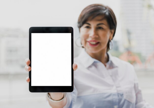 Senior holding a mockup tablet