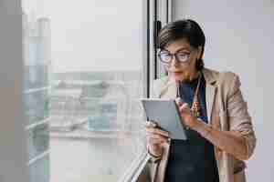 Free photo senior holding a tablet medium shot