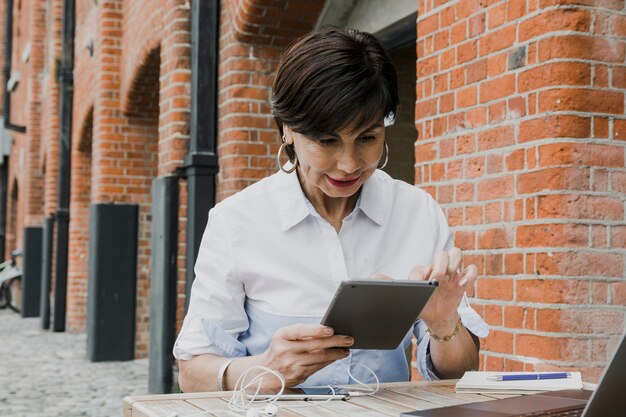 Senior holding a tablet outdoors